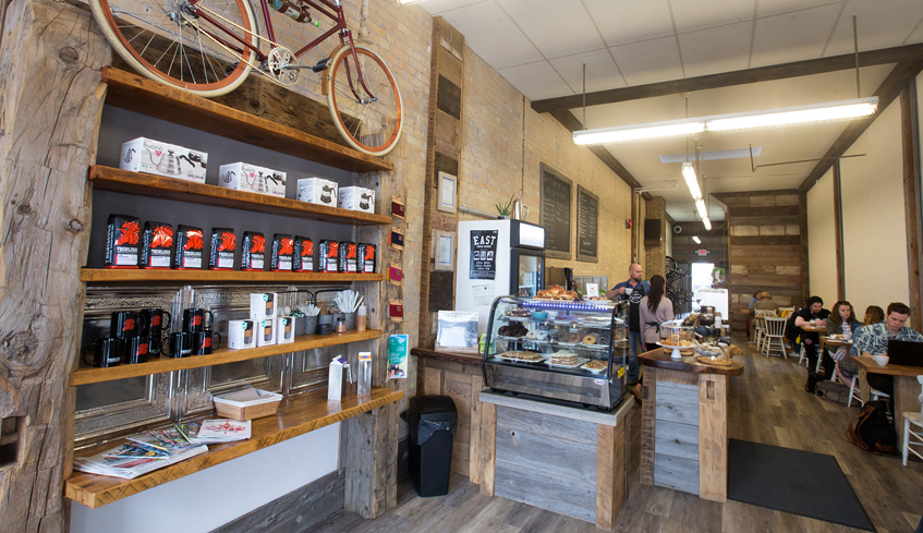 side view interior of coffee shop with bicycle on the wall beside service counter