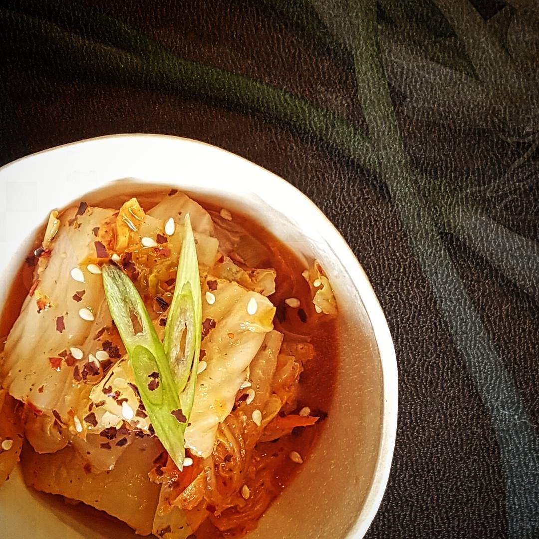 kimchi soup with spices in bowl and garnish on top