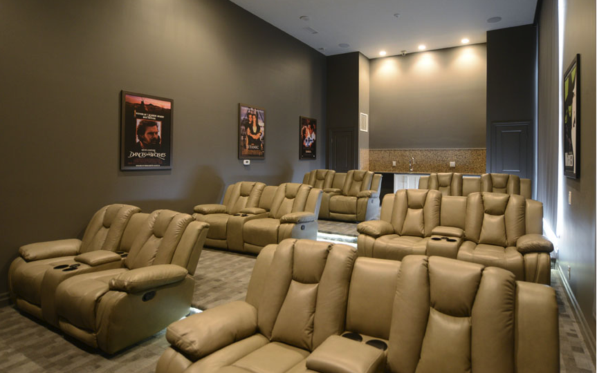 interior of condo movie theatre and lounge room with blinds down and brown recliners