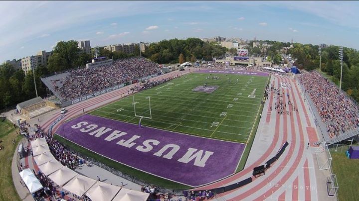 aerial view of full university football stadium with track going around on a sunny day
