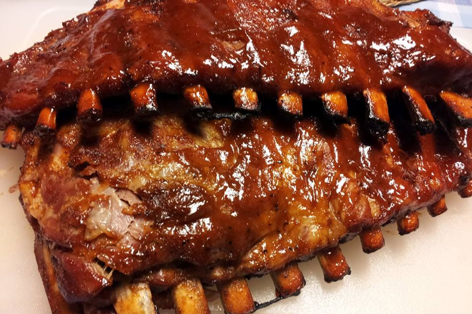 closeup of two full racks of ribs with outside bones exposed on plate