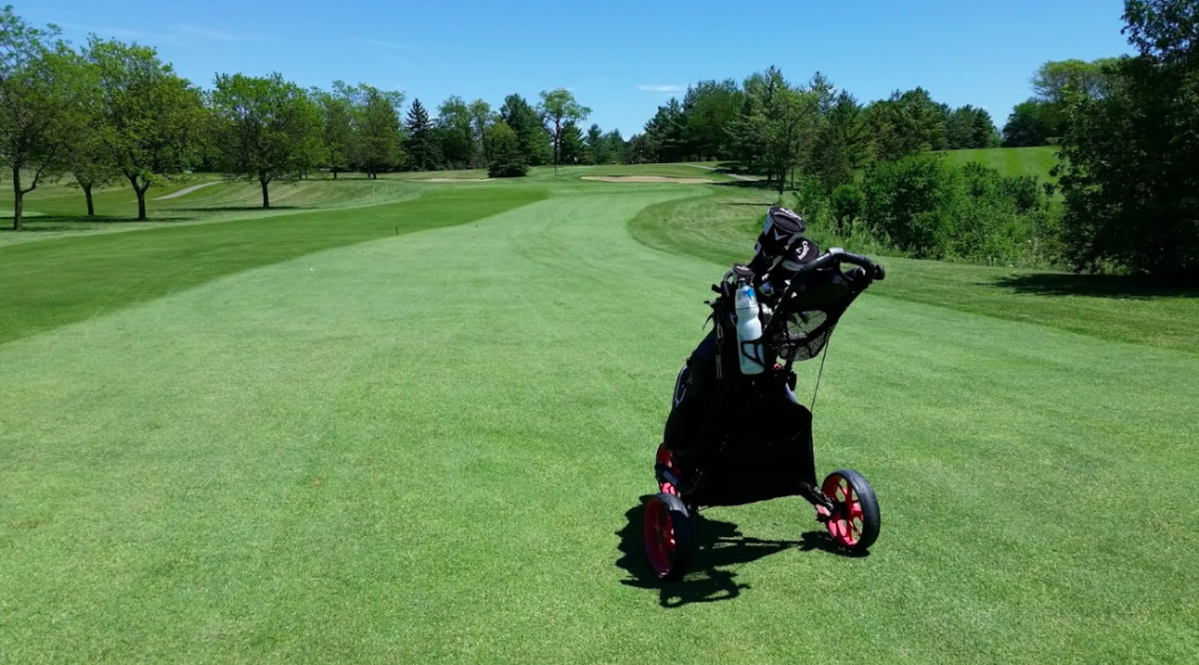 golf bag on walking pully on fairway at course going down fairway