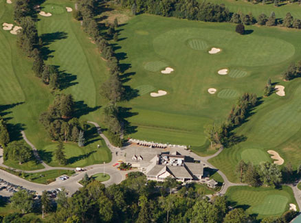 aerial view of most of golf course with bunkers, fairways, trees and clubhouse included