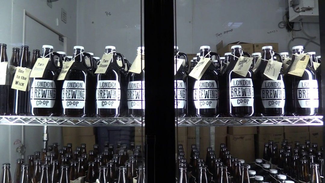close up of beer fridge filled with growlers with tags
