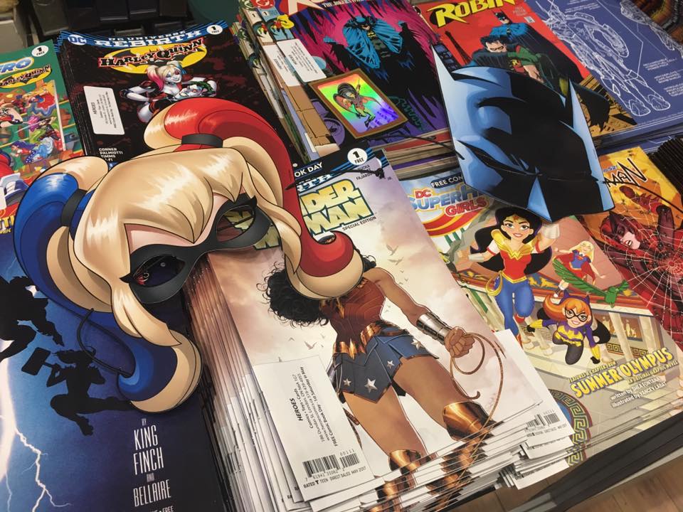 top view of stack of superhero magazines with two masks laying on top of the piles