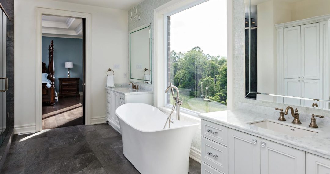 interior of white bathroom with freestanding bathtub beside large mirror